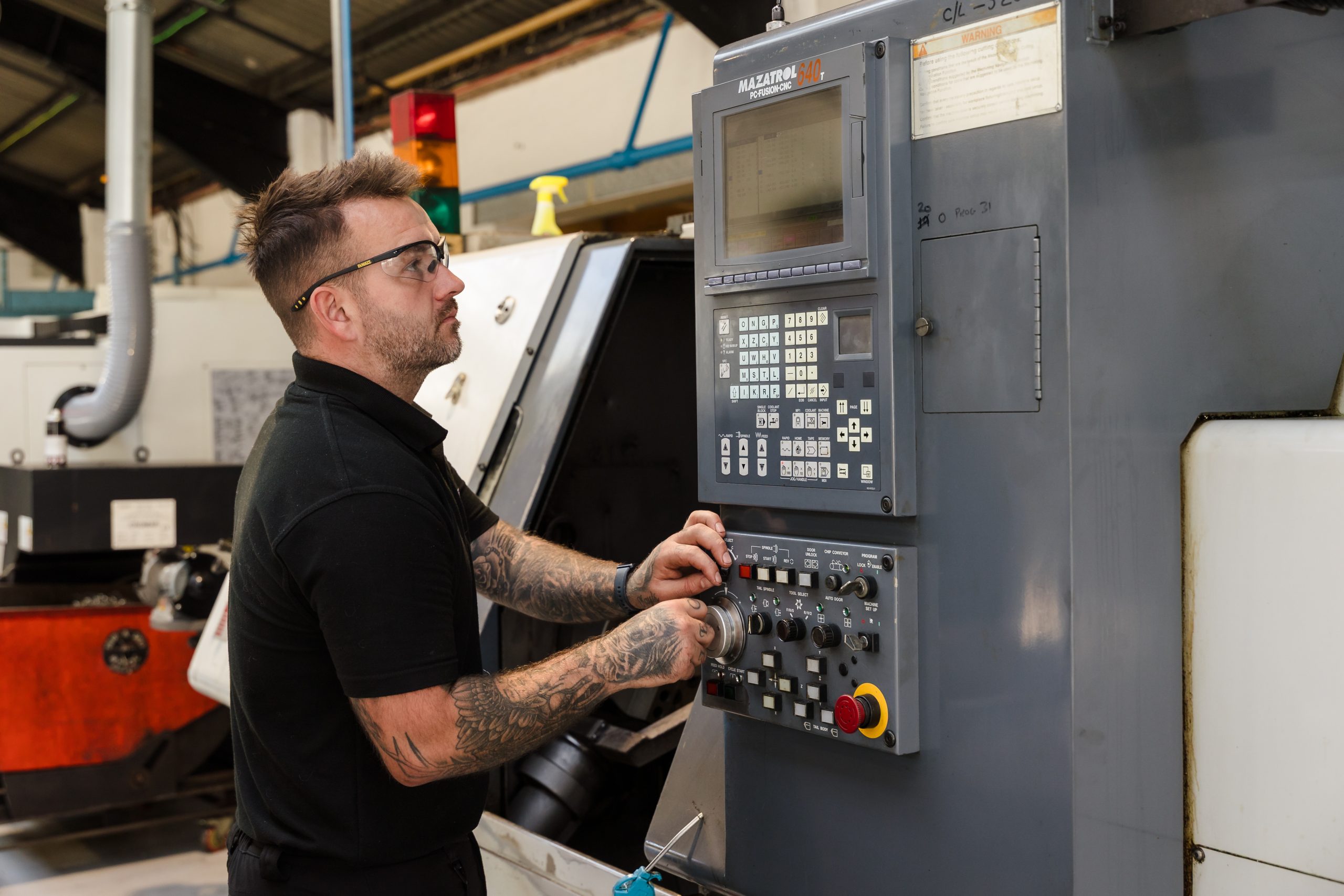 Man with safety goggles programming a machine
